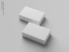 two white boxes sitting next to each other on top of a gray surface with chinese characters in the background