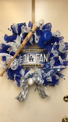 a baseball wreath is hanging on the wall in front of a sign that says la fan