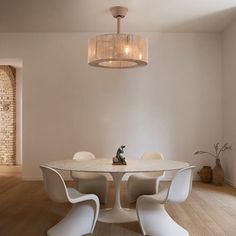 a dining room table with four chairs and a chandelier hanging from the ceiling