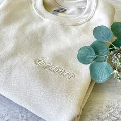 White Cotton Sweater With Embroidered Text, Cream Cotton Sweatshirt With Embroidered Logo, Embroidered Cream Cotton Sweater, Cream Embroidered Cotton Sweater, Cream Cotton Embroidered Sweater, Cream Crew Neck Sweatshirt With Letter Embroidery, Cream Long Sleeve Sweatshirt With Embroidered Text, Embroidered Crew Sweatshirt For Loungewear, Cream Cotton Sweatshirt With Letter Embroidery