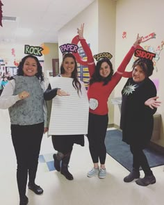 three women are holding up signs in the hallway