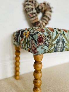 a close up of a wooden bench with fabric on it's back and legs