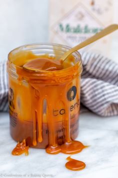 a jar filled with caramel sauce on top of a table next to a bottle