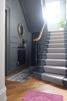 there is a staircase leading up to the second floor in this house with gray walls and wood floors