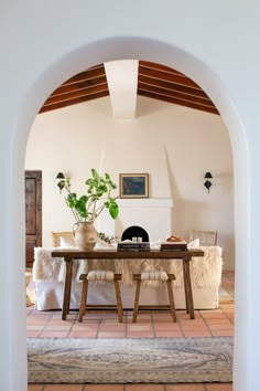 a dining room table with two chairs and a potted plant