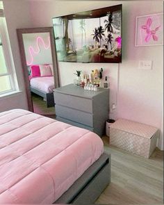 a bedroom with pink and grey decor in the corner, including a large mirror on the wall