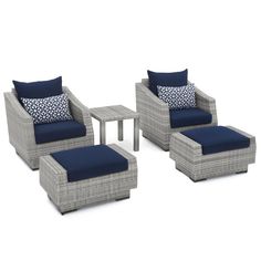 an outdoor furniture set with blue cushions and matching foot stools, coffee table and side table