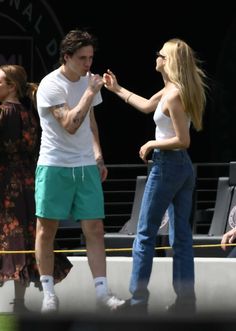 a man standing next to a woman on top of a tennis court