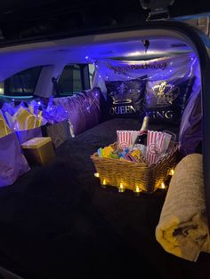 the back of a car with several items in it and lights on inside, including popcorn bags