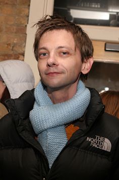 a man wearing a blue scarf and black jacket