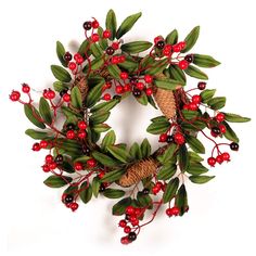 a wreath with red berries and pine cones