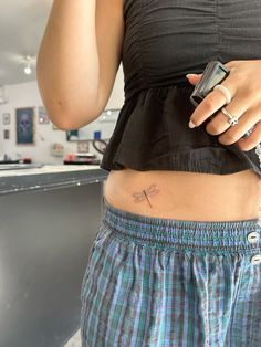 a woman with a cross tattoo on her stomach