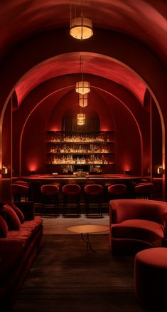 a dimly lit bar with red chairs and stools in front of an arched ceiling