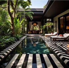 an outdoor swimming pool with lounge chairs and palm trees