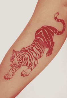 a small tiger tattoo on the arm