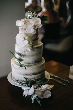 a three tiered cake with flowers on the top is displayed in an instagram