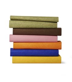 a stack of different colored sheets sitting on top of each other in front of a white background