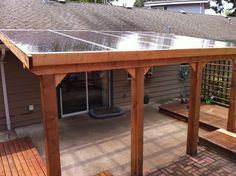 a wooden patio with a solar panel on the roof