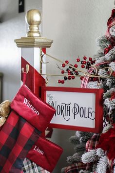 a christmas tree with stockings hanging from it's sides and a sign that says north pole