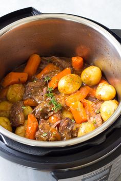 a crock pot filled with beef and potatoes