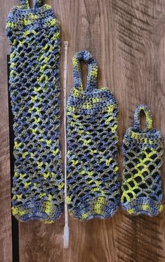 two crocheted bags sitting next to each other on a wooden table with one bag in the middle