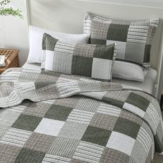 a bed covered in a green and white checkered comforter next to a nightstand