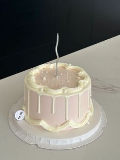 a cake sitting on top of a table with a candle in the middle of it