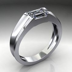 a white gold ring with an emerald cut diamond