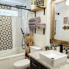 a bathroom with a sink, toilet and bathtub in the background is a tiled shower