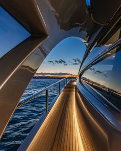 the back end of a boat as it sails through the water at sunset or dawn