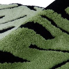 an area rug with black, green and white designs on the carpet is shown in close up