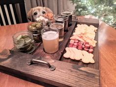 a wooden tray filled with different types of food and drinks on top of a table