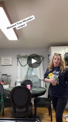 a woman standing in front of a dining room table holding an ice cream sundae