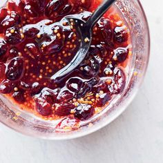 an overhead view of a bowl filled with fruit and seasoning on a white surface