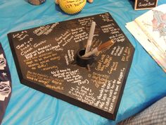 a table topped with writing and baseballs on top of a blue cloth covered table