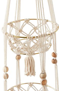 a white macrame mobile with beads and tassels