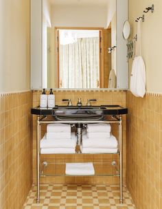 there is a sink in the bathroom with towels hanging on the rack next to it