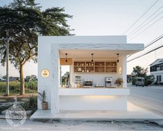 a small white building sitting on the side of a road