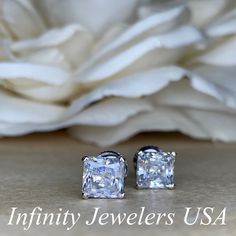 "The stud earrings pictured are simulated diamond #5036 Approximate total carat weight: approx. 2.00ctw diamond equivalent -Center Stone Size: 6x6mm - approx. 1.00ct each diamond equivalent -Center Stone Shape: radiant cut -Gem Type: simulated diamond -Stone Clarity: VVS1 -Stone Color: D -Moh's Scale: 8.5 hardness -Metal Type and Purity: 14k white gold -Setting: 4 prong basket head -Backing: friction back (earring backs are subject to change due to availability) -Country of Manufacturing: USA (M Elegant Gia Certified Earrings For Anniversary, Gia Certified Silver Diamond Earrings For Gift, White Diamond Earrings With Accents For Anniversary, Dazzling Diamond Earrings For Anniversary, Dazzling Bridal Earrings For Anniversary, Gia Certified Sterling Silver Earrings For Anniversary, Cubic Zirconia Bridal Earrings With Diamond Accents For Anniversary, Bridal Cubic Zirconia Earrings With Diamond Accents For Anniversary, Anniversary Bridal Earrings With Cubic Zirconia Accents