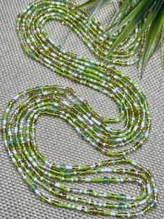 -Listing is for one 52 inch tie-on luxury waist bead -Created on a durable polyester string -Genuine Preciosa Czech glass bicone crystal beads -A blend of glass Toho seed beads -Colors: green, clear, white, gold Benefits of waist beads:  Monitor weight loss/gain: as you lose weight your weight, your waist beads will fall down towards your hips; as you gain weight your waist beads will get tighter and rise up your waist Increase sensuality: very enticing in the bedroom; men love to see them move Waistbeads Tools, Bohemian Green Waist Beads With Colorful Beads, Bohemian Green Waist Beads, Green Tiny Beads Waist Beads Gift, Green Tiny Round Beads Waist Beads, Green Waist Beads For Gift, Green Colorful Waist Beads For Beach, Green Waist Beads For The Beach, Green Waist Beads For Beach