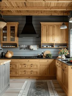 a kitchen with wooden cabinets and black counter tops, along with an area rug on the floor