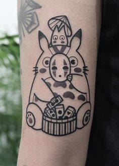 a person with a tattoo on their arm that has an image of a cat sitting in a basket