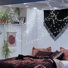 a bed room with a neatly made bed and lots of string lights hanging from the ceiling