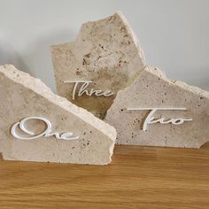 three pieces of stone with the words time to go written on them sitting on a wooden table