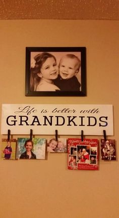 a family photo hangs on the wall above a sign that says, it's better with grandkids