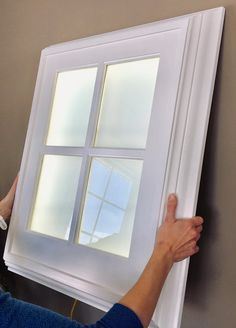 a person is painting a window with white paint