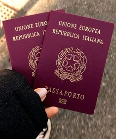 two people are holding their passports in their hands