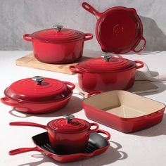 red pots and pans are sitting on a table