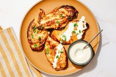 grilled chicken with ranch dressing on a plate next to a small bowl of ranch dressing