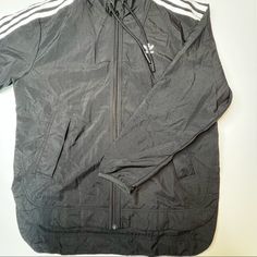 Sleek Black Windbreaker By Adidas! Black With White Stripes. Clasp Closure Pockets. Zip Up Jacket. Adjustable Drawstring Hood. Size Small. Nwt! 7.24 Adidas Outerwear With Adjustable Hood For Fall, Urban Adidas Black Windbreaker, Nylon Track Jacket With Double-lined Hood, Adidas Urban Black Windbreaker, Black Spring Windbreaker With Drawstring Hood, Spring Black Windbreaker With Drawstring Hood, Adidas Windbreaker With Pockets For Spring, Adidas Outerwear With Drawstring Hood For Streetwear, Adidas Urban Long Sleeve Windbreaker